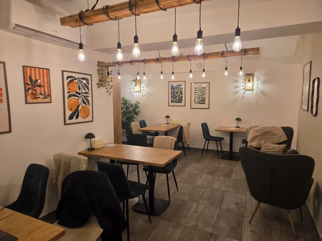 The Siesta Cafe room — wooden tables and a row of bulbs along the ceiling