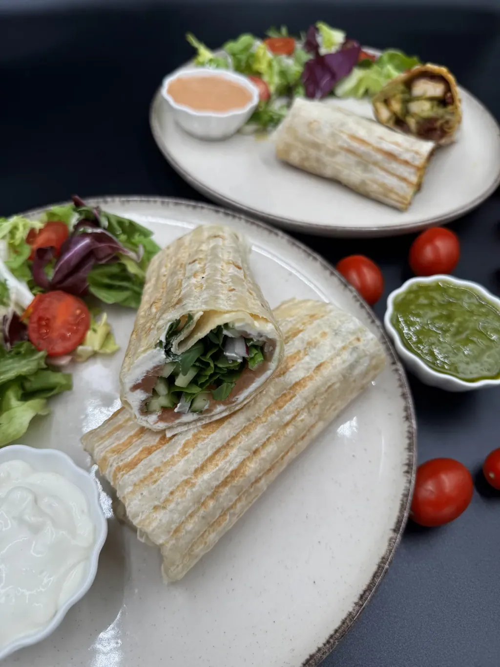 A wrap with side salad and dips